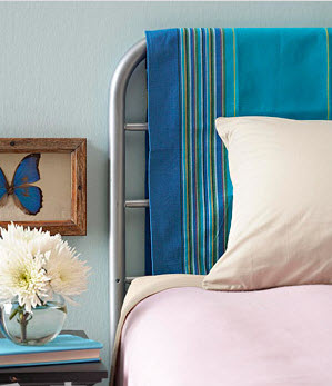 Một tấm vải treo phía đầu giường màu xanh với những đường sọc nhiều màu sắc không chỉ tạo ra bầu không khí thư giãn, nghỉ ngơi mà còn làm cho căn phòng trông tươi trẻ và có chiều sâu hơn.